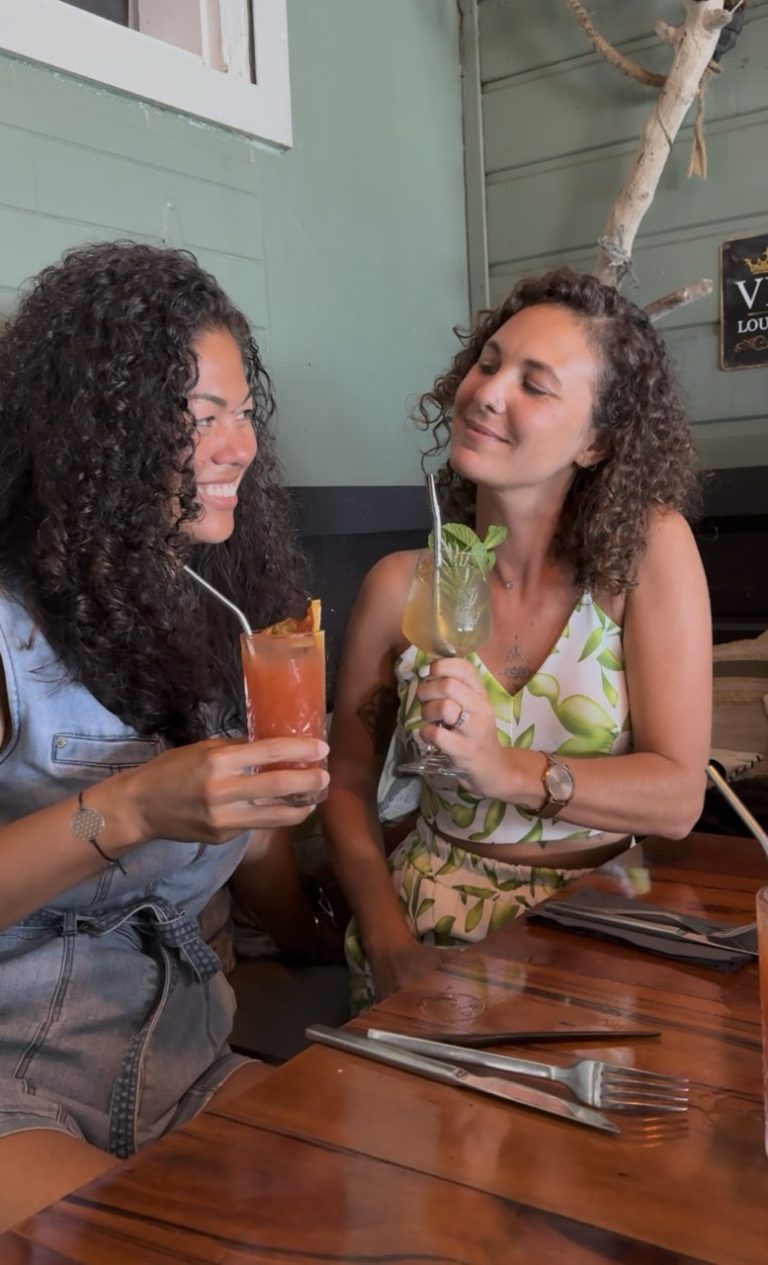 Ambre TAC et une amie dégustant des cocktails au restaurant Le Rhumarin à Saint-François en Guadeloupe, adresse réputée pour sa cuisine raffinée et ses produits de qualité.