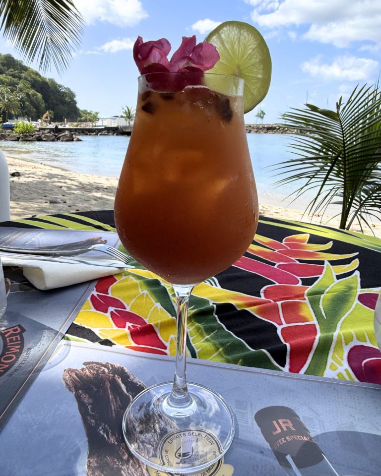 Cocktail servi au restaurant Chez Lèlette à Deshaies en Guadeloupe avec vue sur la plage et la mer dans une ambiance tropicale en bord de sable.