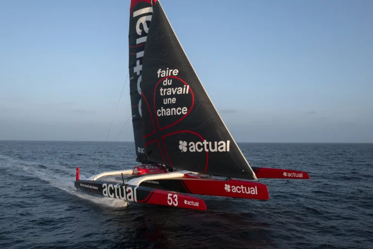 Trimaran ULTIM Actual en course lors de la Route du Rhum 2026 – Destination Guadeloupe, bateau de compétition naviguant à grande vitesse sur l’océan Atlantique.