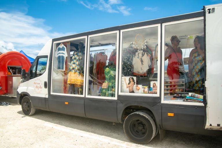 Boutique mobile de vêtements et accessoires installée lors de La Foire des Roulottes à Pointe-à-Pitre en Guadeloupe avec mode, artisanat et visiteurs pendant l’événement.