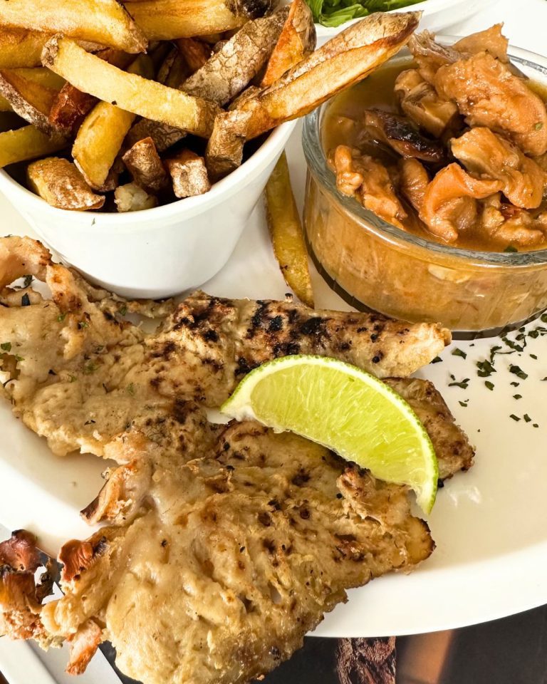 Assiette de lambi grillé avec frites maison et sauce créole au restaurant La Kaz a Loulouz au Gosier en Guadeloupe.