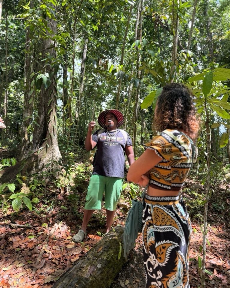 Didreau partage ses connaissances sur la culture de la vanille face à Ambre TAC lors d’une immersion en forêt à la Vanilleraie Wild Forest en Guadeloupe.